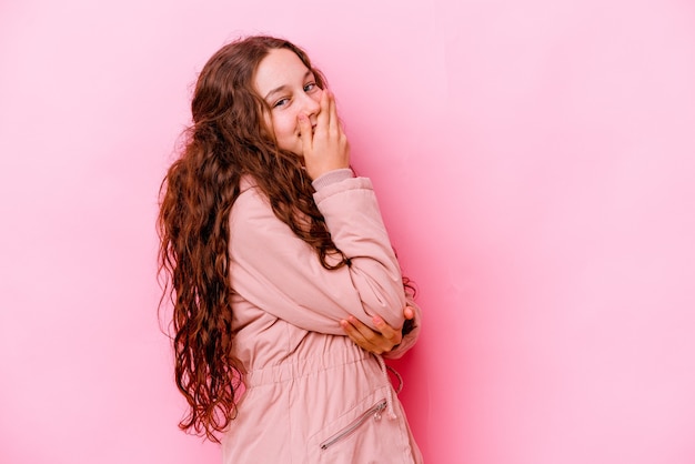 Niña caucásica aislada en rosa riendo feliz, despreocupada, natural emoción.