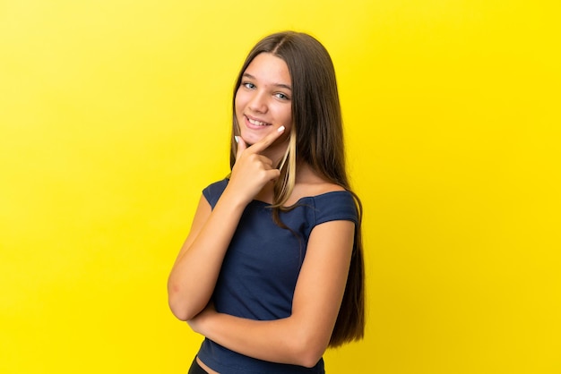 Niña caucásica aislada sobre fondo amarillo feliz y sonriente