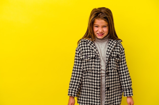 Niña caucásica aislada sobre fondo amarillo gritando muy enojado, concepto de rabia, frustrado.