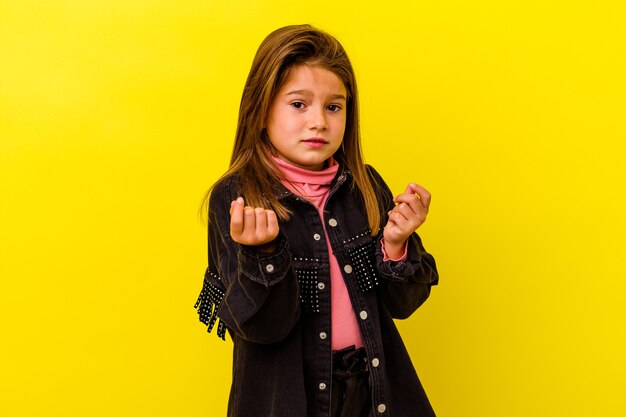 Niña caucásica aislada sobre fondo amarillo mostrando que no tiene dinero.