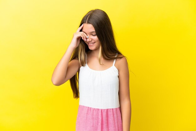 Niña caucásica aislada sobre fondo amarillo riendo