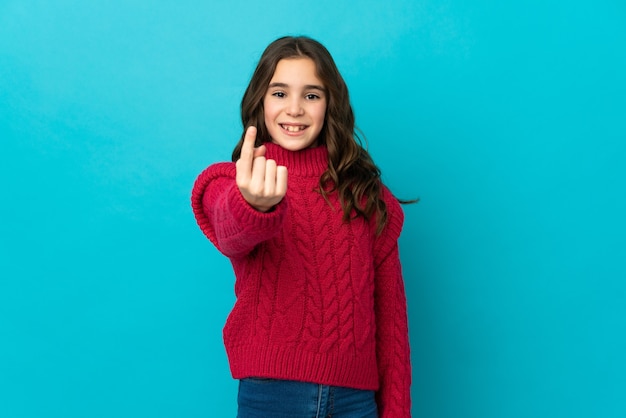 Niña caucásica aislada sobre fondo azul haciendo gesto de venida