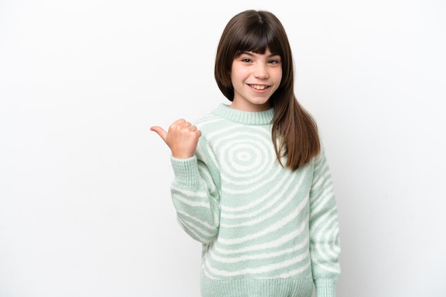 Niña caucásica aislada sobre fondo blanco apuntando hacia el lado para presentar un producto