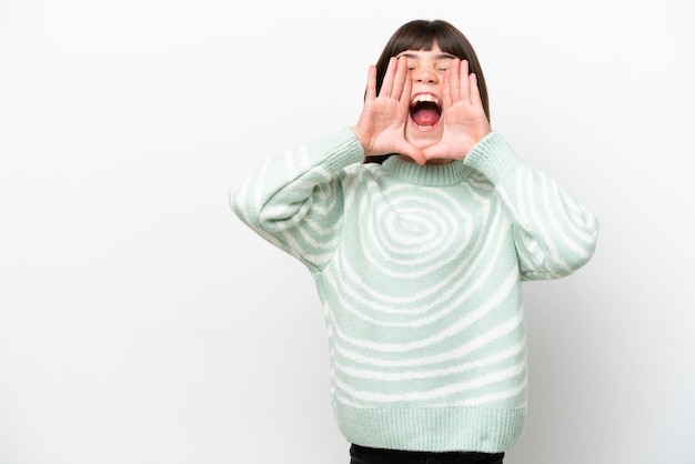 Niña caucásica aislada sobre fondo blanco gritando y anunciando algo