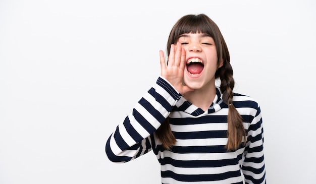 Niña caucásica aislada sobre fondo blanco gritando con la boca abierta