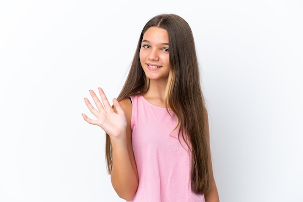 Niña caucásica aislada sobre fondo blanco saludando con la mano con expresión feliz