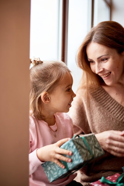 Niña caucásica besar a su madre Concepto de Navidad de familia feliz