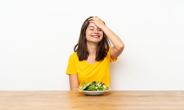 Niña caucásica con ensalada riendo