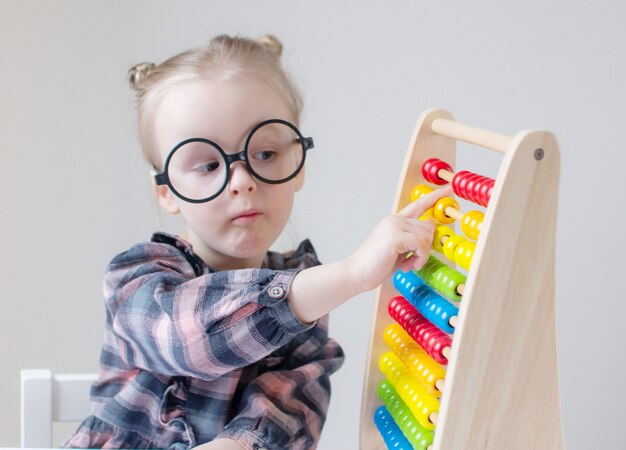 Niña caucásica con gafas redondas.