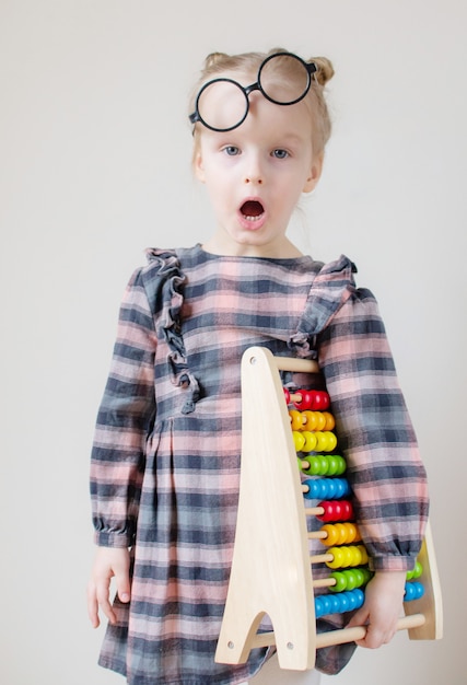 Niña caucásica con gafas redondas.