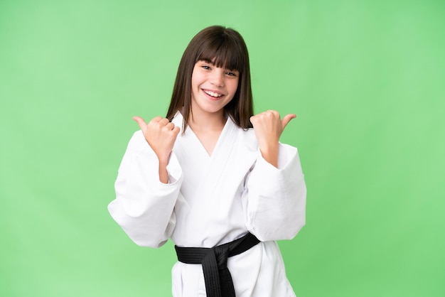 Niña caucásica haciendo karate sobre un fondo aislado con gesto de aprobación y sonriendo