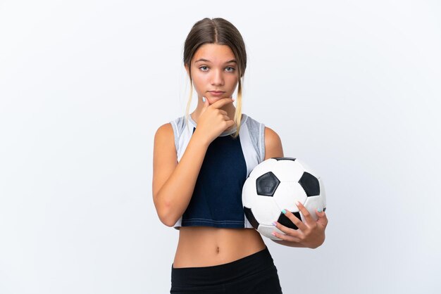 Niña caucásica jugando al fútbol aislada en el pensamiento de fondo blanco