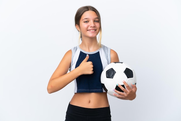 Foto niña caucásica jugando al fútbol aislado sobre fondo blanco dando un gesto de pulgar hacia arriba