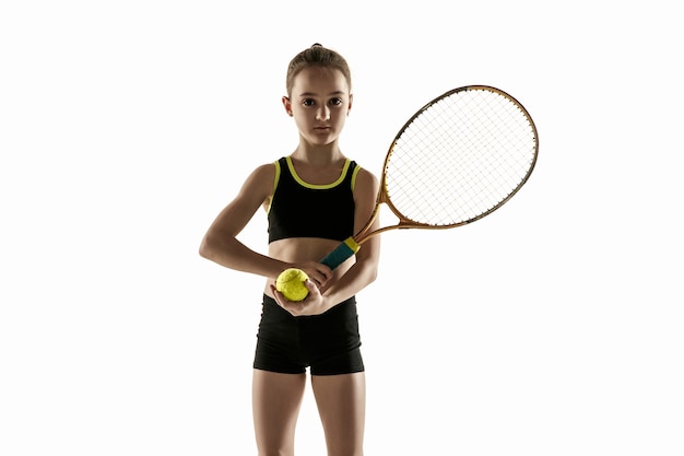 Niña caucásica jugando al tenis aislado sobre fondo blanco.