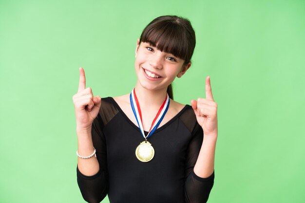 Niña caucásica con medallas sobre un fondo aislado que señala una gran idea