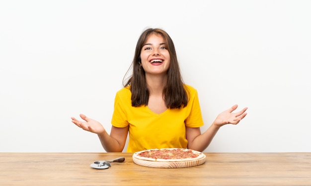 Foto niña caucásica con una pizza infeliz y frustrada con algo