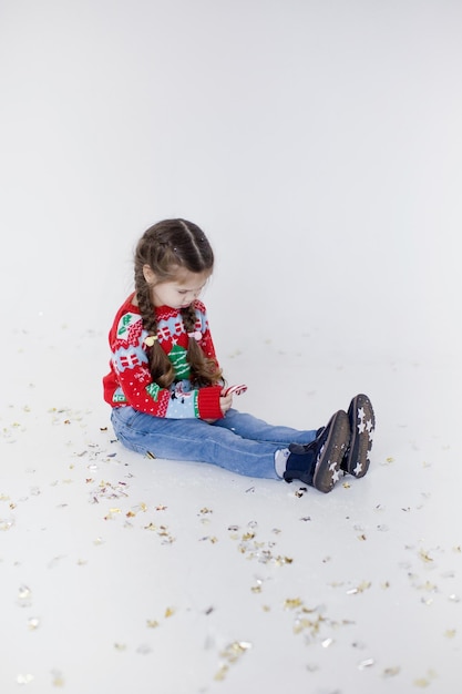 Niña caucásica preescolar en suéter de Navidad