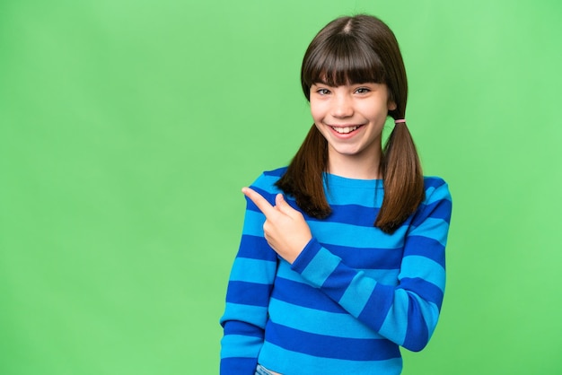 Niña caucásica sobre un fondo aislado apuntando hacia un lado para presentar un producto