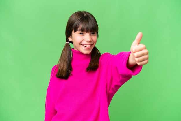 Niña caucásica sobre un fondo aislado dando un gesto de pulgar hacia arriba