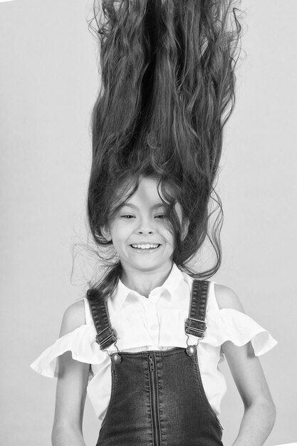 Niña caucásica con viento en cabello moreno