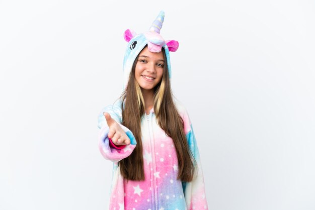 Niña caucásica vistiendo pijama de unicornio aislado sobre fondo blanco un apretón de manos para cerrar un buen trato