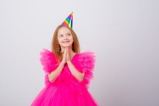 Una niña celebra su cumpleaños sobre un fondo blanco.