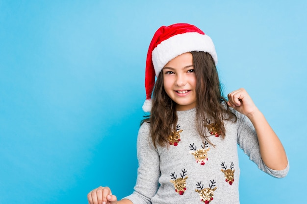 Niña celebrando el día de Navidad bailando y divirtiéndose.