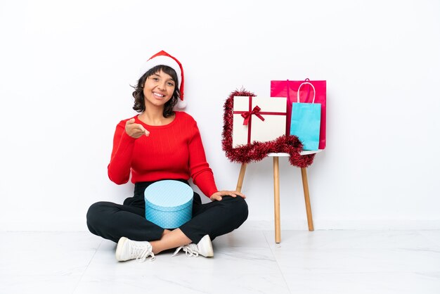 Niña celebrando la Navidad sentados en el suelo aislado en blanco bakcground estrecharme la mano para cerrar un buen trato