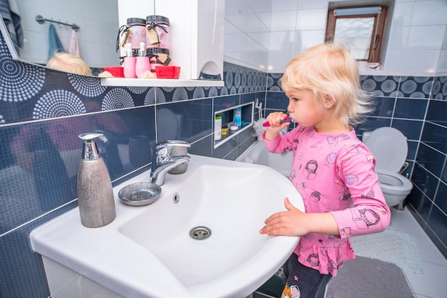 niña se cepilla los dientes en el baño