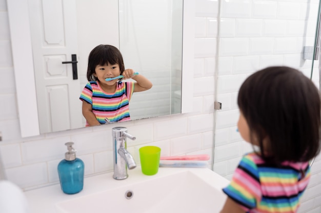 La niña se cepilla los dientes de forma independiente