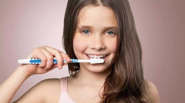 Niña cepillarse los dientes aislado en blanco