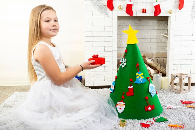 Niña cerca del árbol de Navidad