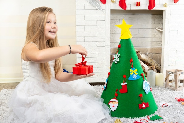 Niña cerca del árbol de Navidad