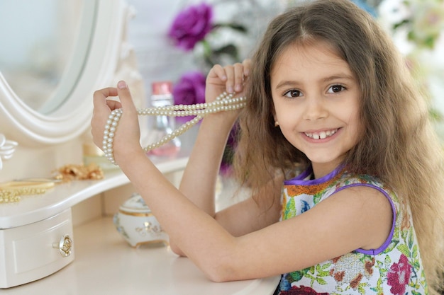 Niña cerca del espejo. Princesa linda en vestido hermoso