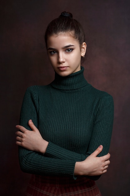 Una niña en una chaqueta verde en un oscuro