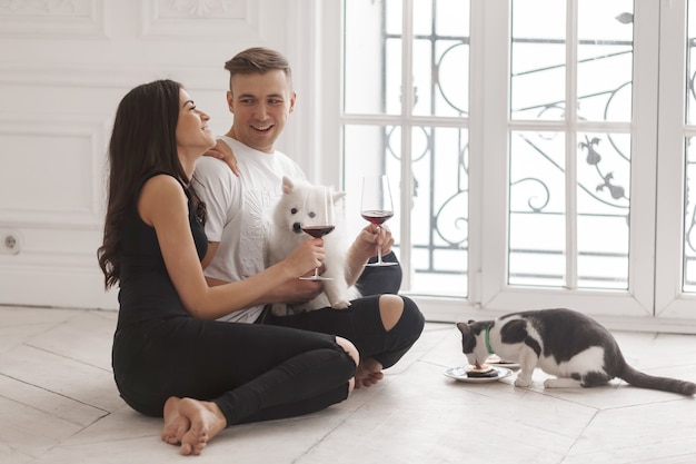 Foto una niña y un chico se sientan en una casa nueva en el suelo con sus mascotas.