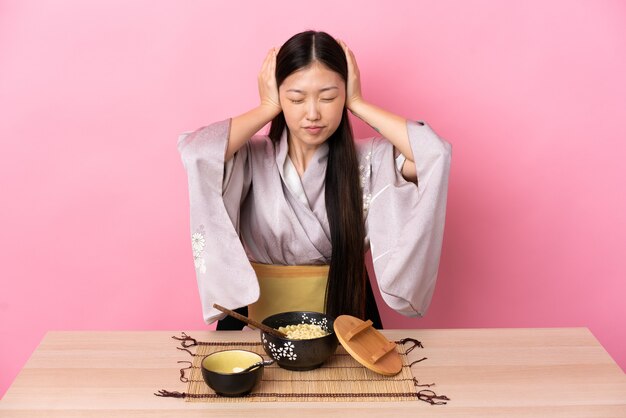 Niña china con kimono y comiendo fideos frustrados y coning orejas