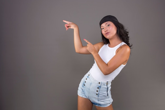 Niña china con pañuelo y camiseta aislada apuntando hacia el lado mostrando algo