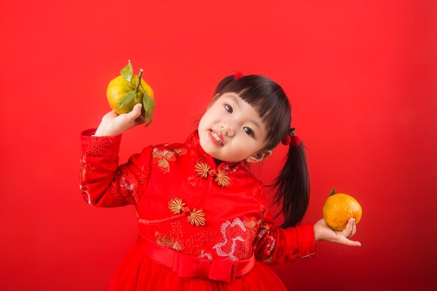 Una niña china sosteniendo naranjas para el Festival de Primavera.