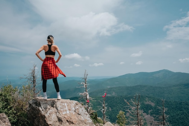 Una niña en la cima de la montaña Falaza mira un hermoso valle montañoso Viajes y turismo Senderismo