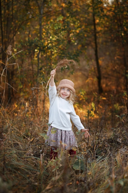 Niña de cinco años en el bosque de otoño en un paseo