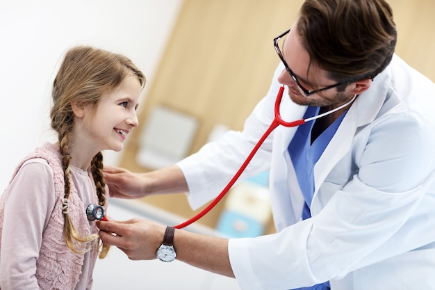 Niña en la clínica siendo examinada por el pediatra