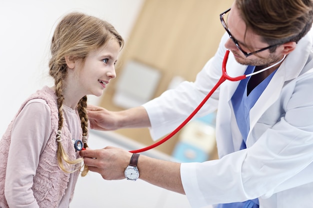 Niña en la clínica siendo examinada por el pediatra