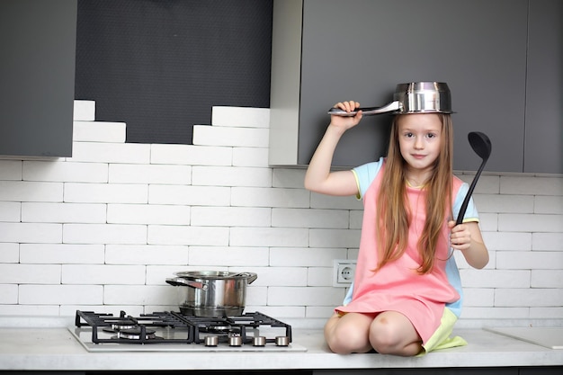 Niña en la cocina posando en la cámara