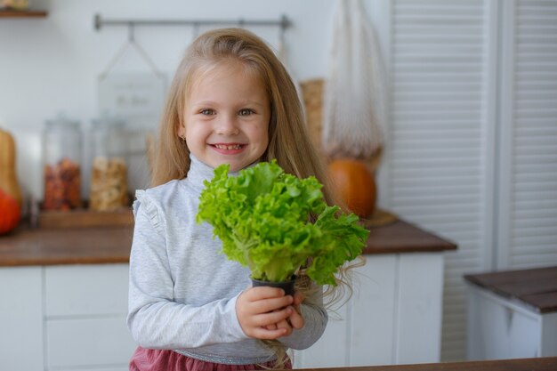 niña en la cocina con verduras sonrisas