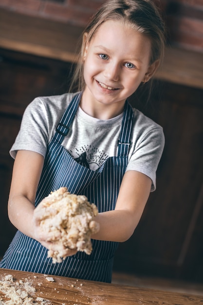 Niña cocinando masa en la cocina