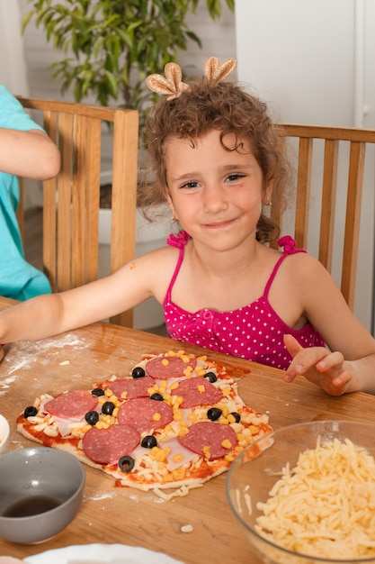 La niña cocinó su pizza favorita.