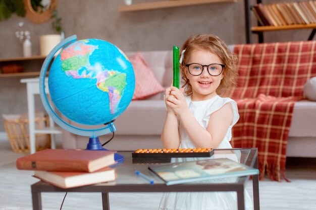 Niña colegiala con gafas está comprometida en casa