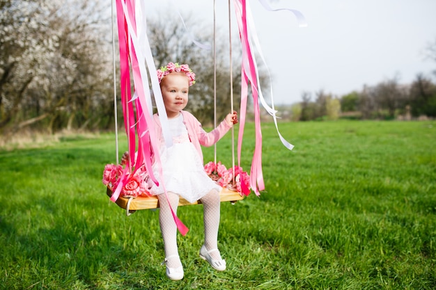 Foto niña en el columpio, niña en el parque