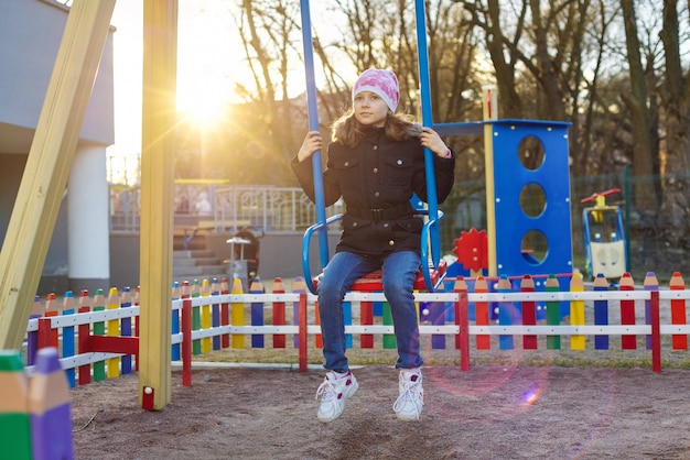 Niña en columpio, parque infantil